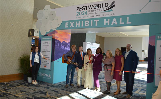 The PestWorld 2024 ribbon-cutting ceremony featured, from left, NPMA Director of Meetings & Exhibits Megan Moloney, Chris Collins of the John Denver Tribute Band and National Pest Management Association board of directors Bob Dold, Marillian Missiti, Faye Golden, Dominique Stumpf, Emily Thomas Kendrick and Mike Bullert. PHOTO: PMP STAFF